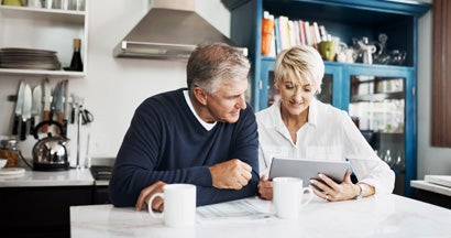Mature couple using digital tablet to search for an annuity specialist