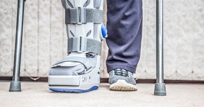 mature woman wearing leg brace and crutches